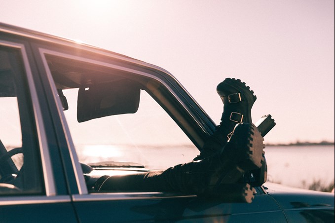 Woman with her feet out the car window