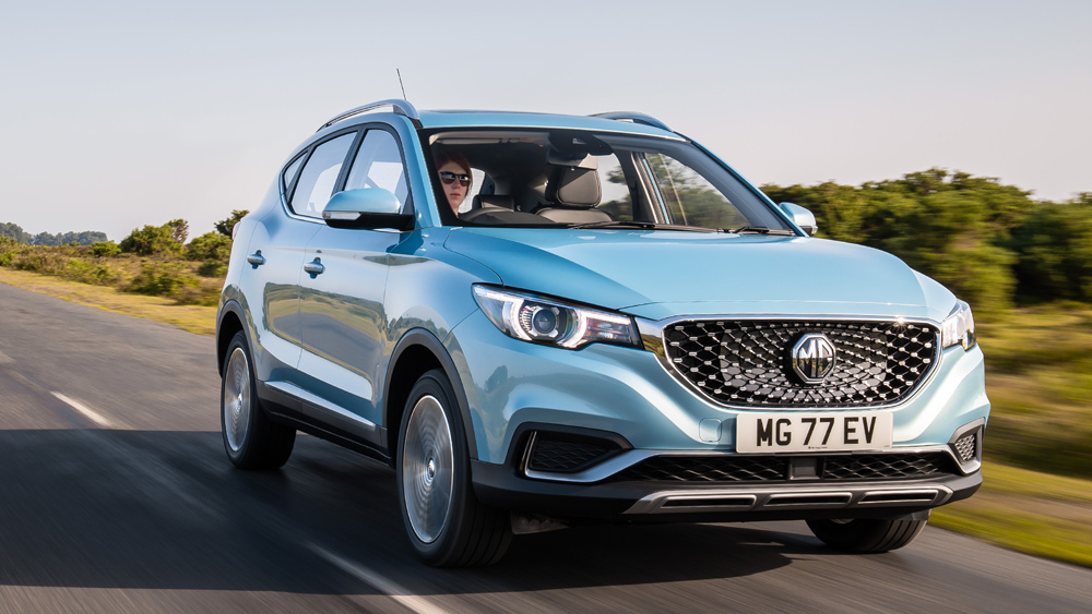 Light blue MG ZS crossover SUV cruises down a country road